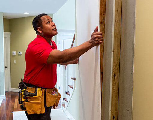 handyman hanging the picture into the wall